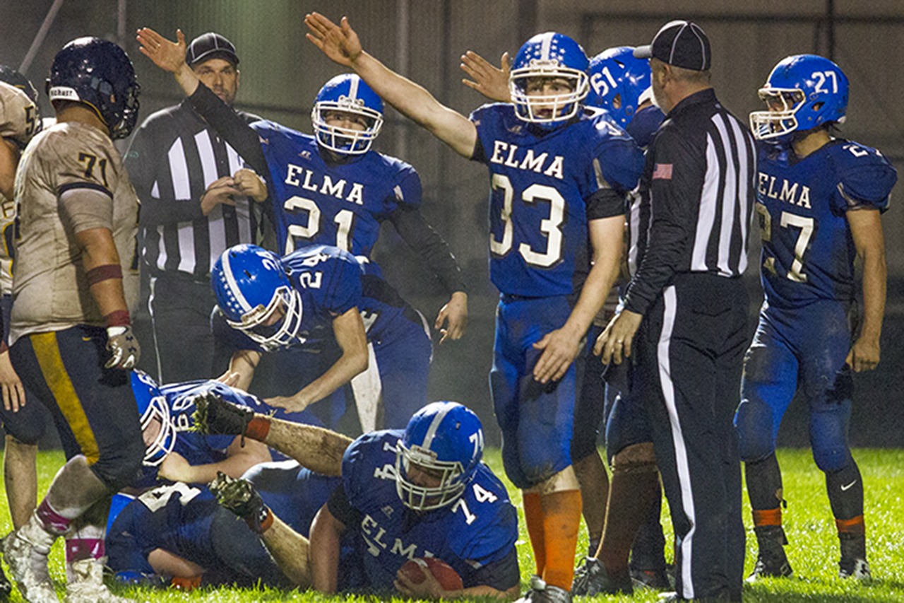 (Photo by Justin Damasiewicz)                                Several Eagle players signal that they have recovered a Forks fumble while A.J. Hernandez clutches the ball on the ground during an Evergreen 1A League football game on Friday at Davis Field. The official eventually ruled that the Forks runner was down before the ball came loose.