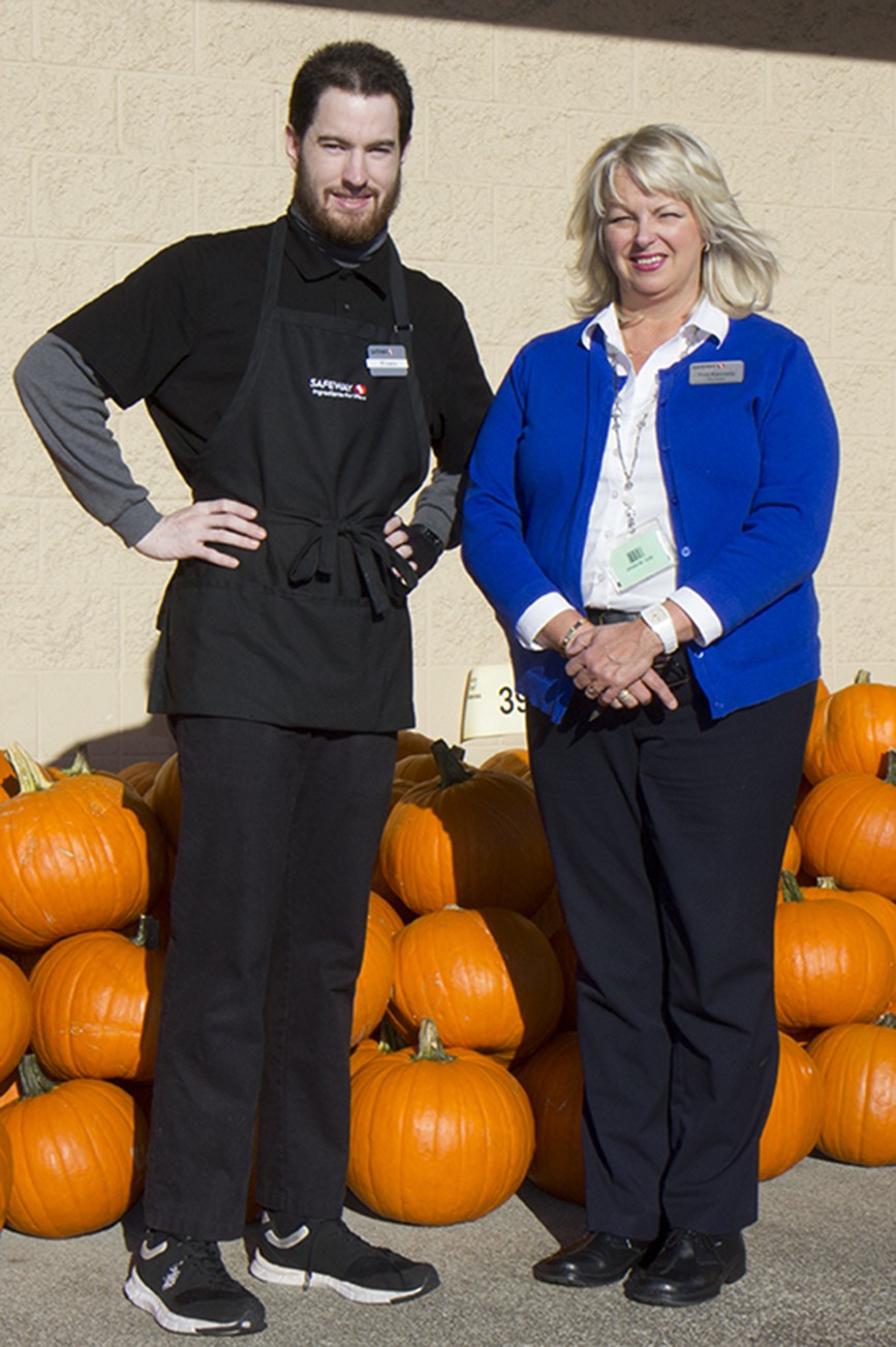 (Stephanie Morton | The Vidette)                                Tom Elliott (left) and Safeway store director Patti Kennedy stand by rows of fall pumpkins outside the Aberdeen store.