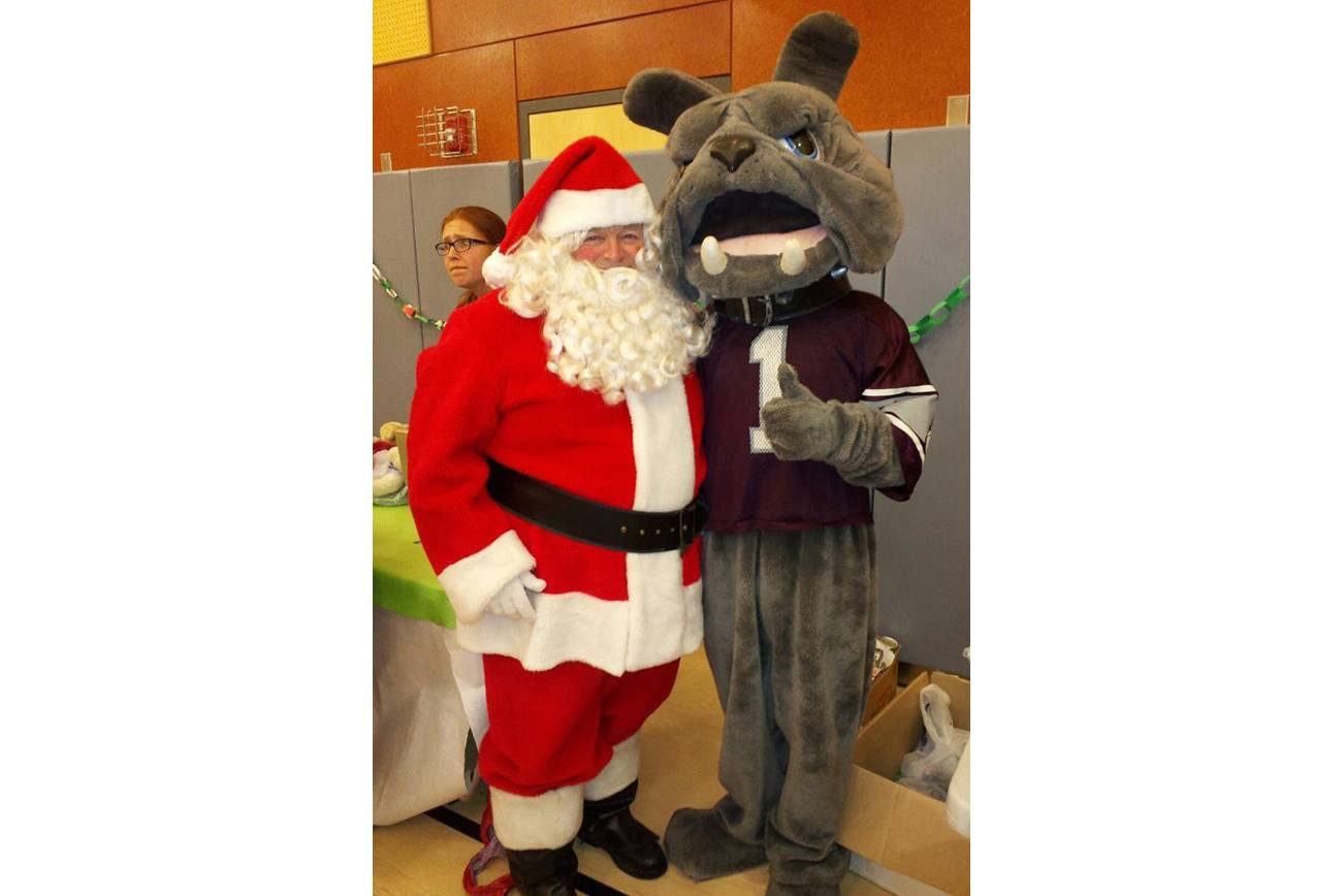 Courtesy photo provided by Dennis Brumbaugh Dennis Brumbaugh as Santa’s helper posing for a photo with the Montesano Junior/Senior High School Bulldog mascot during a Christmas past. Brumbaugh is planning to hang up his Santa suit at the end of the Christmas season.