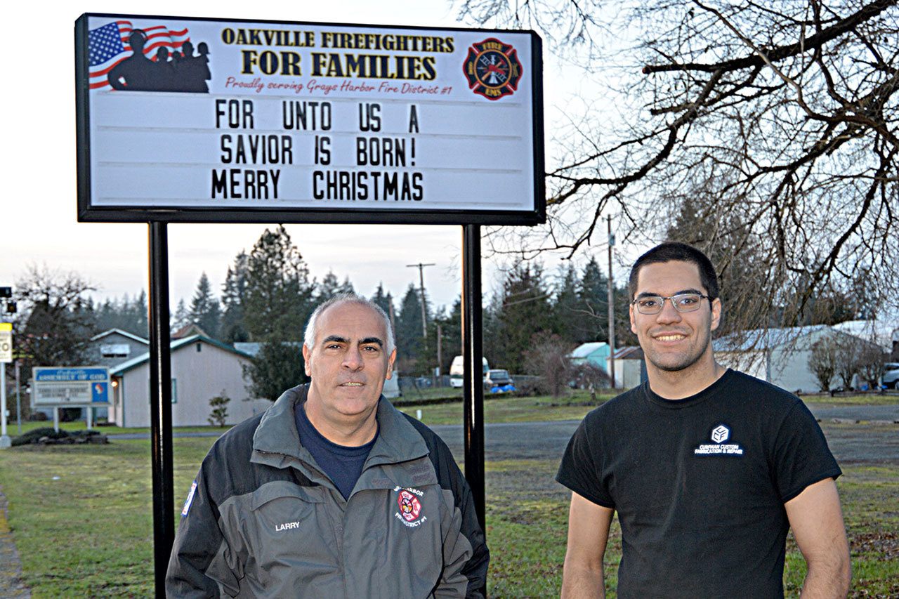 Larry Curfman and his son Jonathan stand in front of Oakville Fire Department’s new Christmas sign. Last year a similar sign created controversy; this year the sign was placed on private property and was paid for with donations to the nonprofit Oakville Firefighters for Families organization. Jonathen and his brother Jason Curfman of Curfman Custom Fabrication and Repair donated the labor required to build the framework and install the sign.