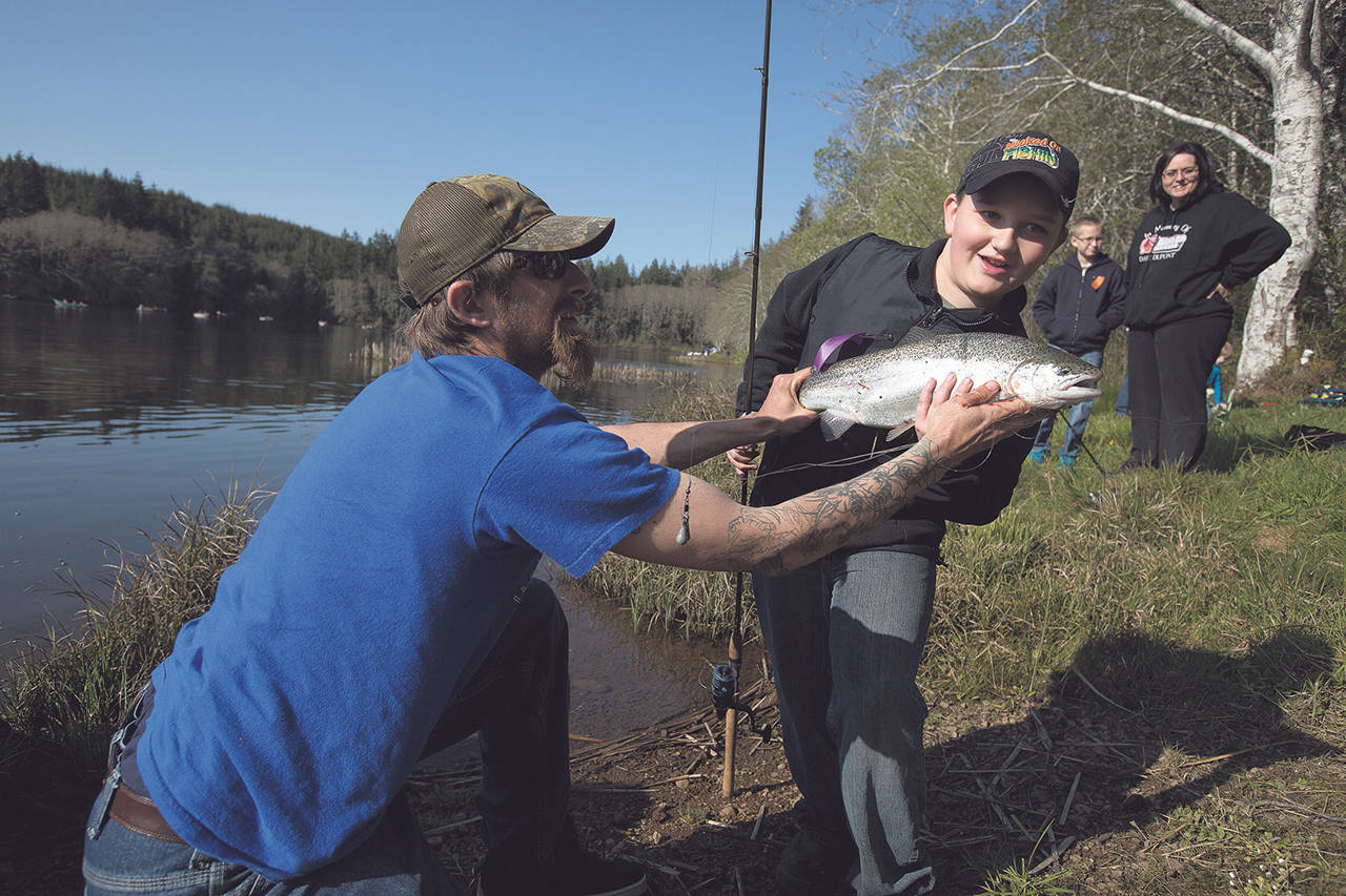 After a quick battle for his catch, Bryson Brown holds up a trout that he entered into the Grays Harbor Poggie Club kids-only fishing derby held at Failor Lake in 2015. (Daily World File Photo)