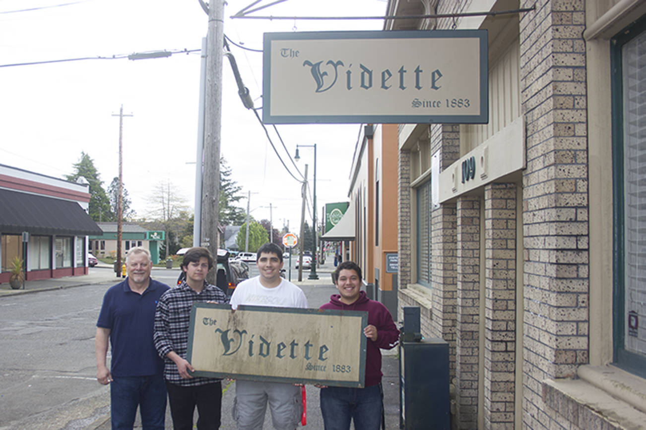 (Corey Morris | The Vidette) From left, Montesano High School CTE instructor James Wark, and MHS seniors Joel Dillard, Matthew Johnson and Ben Lopez pose holding the old, weathered Vidette sign. The quartet along with MHS senior Roy Moe and CTE instructor Jeff Wetzel recently built a new sign.