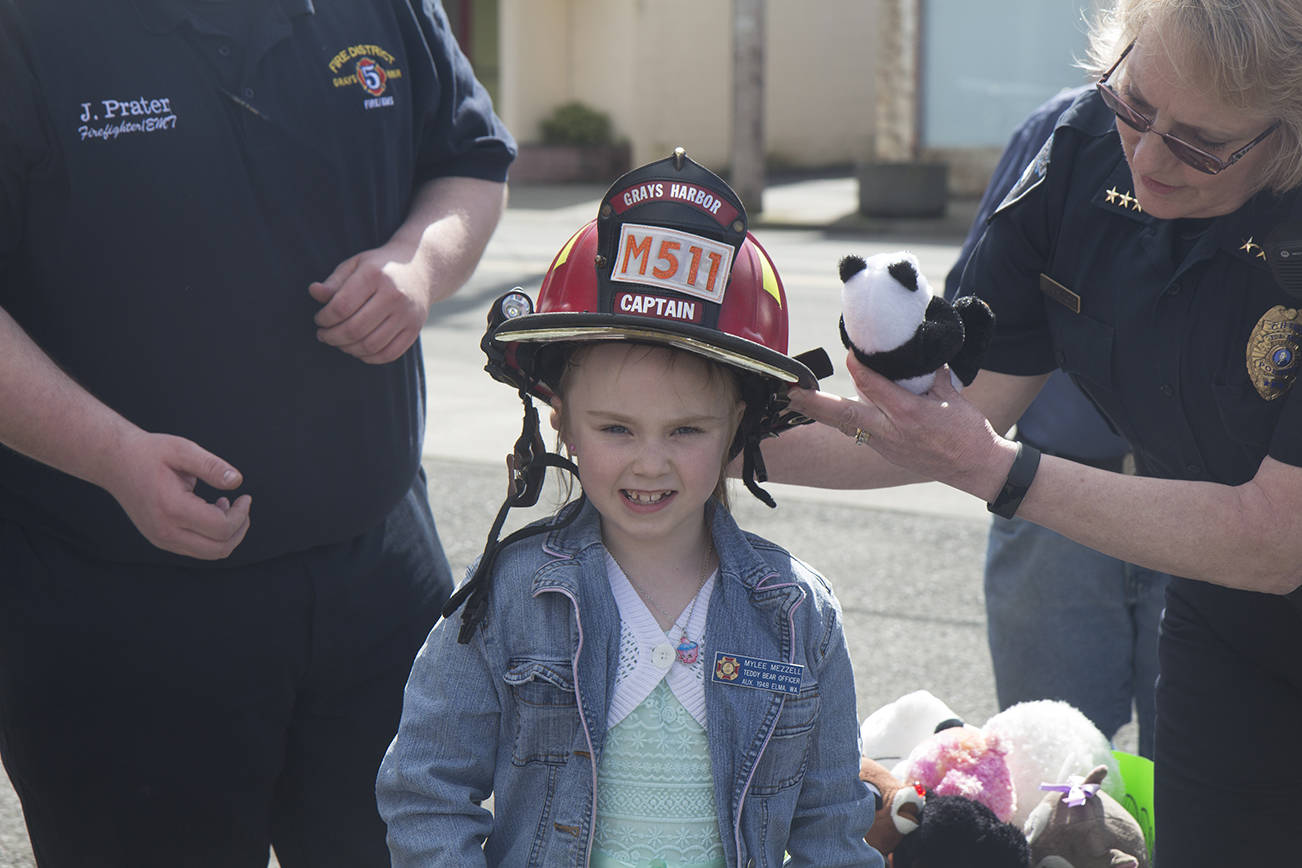 (Travis Rains | The Vidette) Teddy bear officer Mylee Mezzell is dubbed captain for a few short minutes while dropping off collected stuffed animals April 30. Jake Prater (left) and Chief Shultz (right).