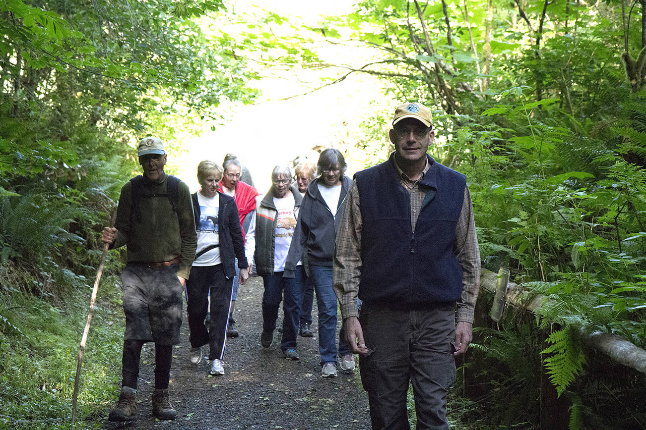 (Travis Rains | The Vidette) Montesano City Forester Loren Hiner (right) leads a group on the first hike of this year’s A Walk in Our Woods on Lake Sylvia State Park’s Forestry Trail.