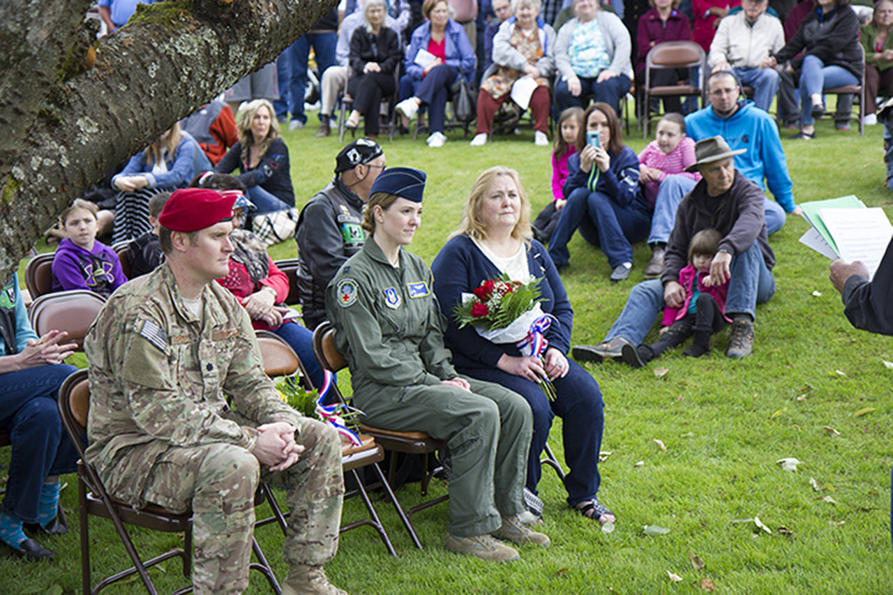 (Corey Morris | The Vidette) Lt. Col. Dan Magruder, Noel Carroll and Sally Sheldon listen to a ceremony on Memorial Day, May 29, for the unveiling of a memorial street sign at the intersection of Academy Street and Pioneer Avenue in Montesano. The memorial sign was for Tim Davis who was killed in Afghanistan in 2009. Magruder served with Davis in Afghanistan, Carroll is Davis’ sister, and Sheldon is Davis’ mother.