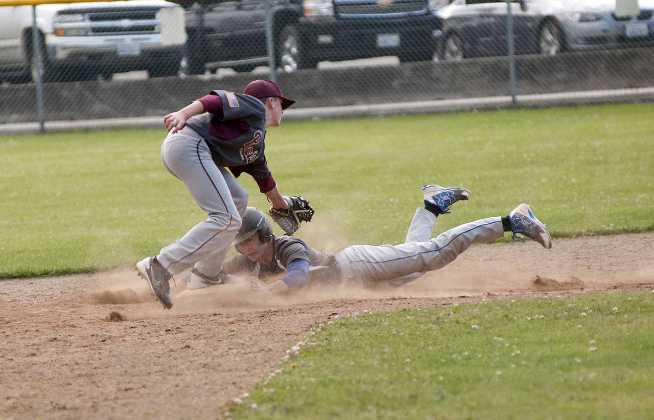 (Brendan Carl | Grays Harbor Newspaper Group) Elma Pharmacy’s Colten French slides under the tag of Precision Pipe’s Braden Dohrmann on Tuesday.