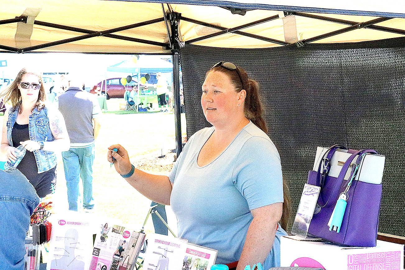 (Travis Rains | The Vidette) Representative for Damsel in Defense, Amber Cowgill, answers questions about her products at the Saturday Morning Market at Montesano’s Fleet Park July 8.