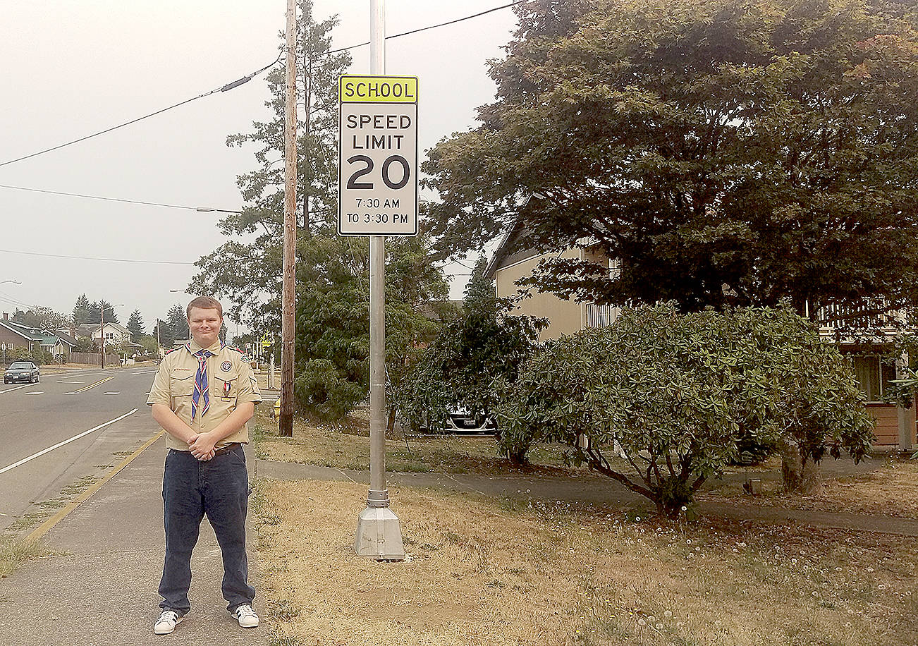 (Courtesy photo) Eagle Scout Justin Gay stands next to his recently completed Eagle Project, crosswalk caution lights marking the Elma Junior and Senior High school zones.