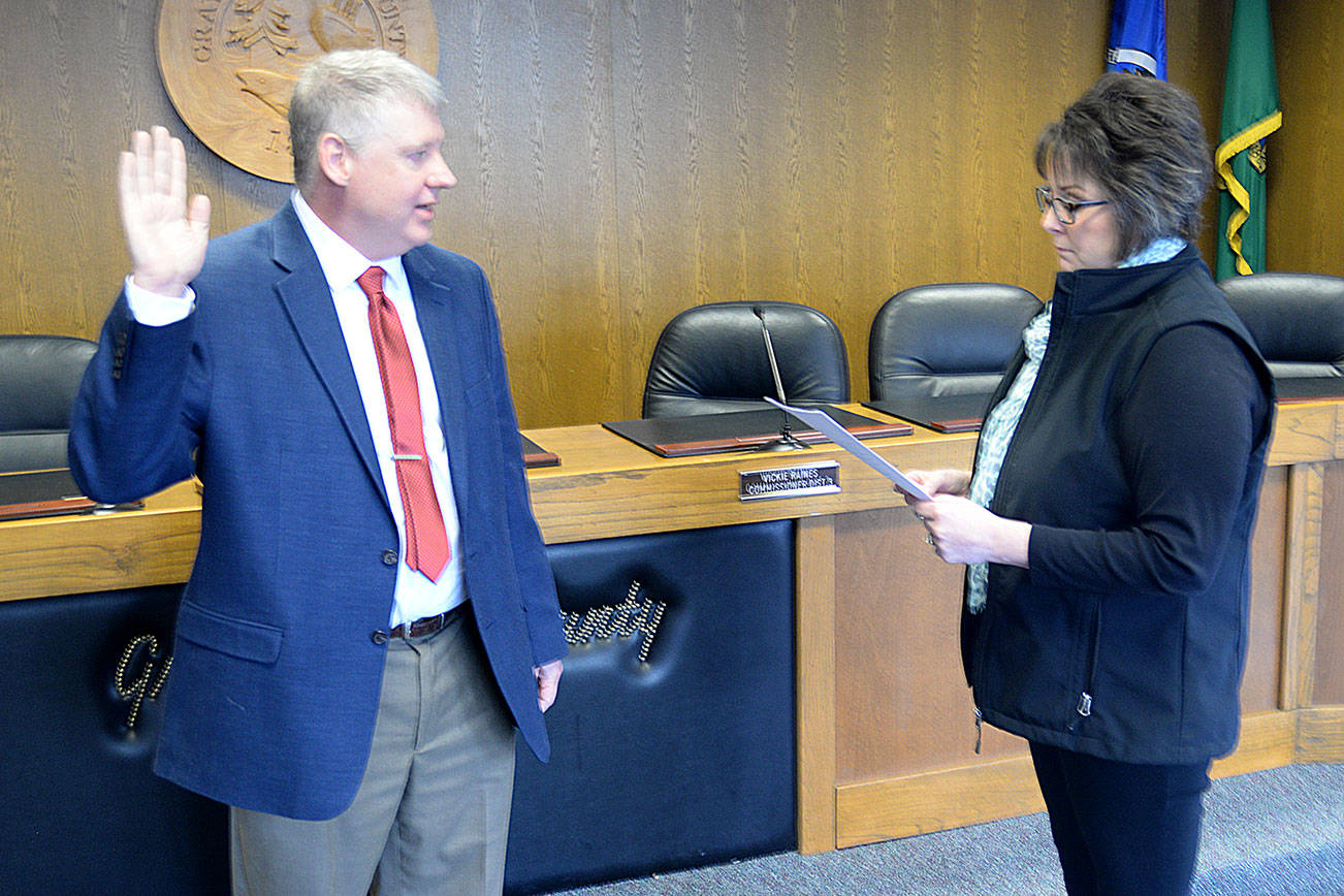 (Dan Hammock | Grays Harbor Newspaper Group) Chris Thomas of Montesano is sworn in to office by Grays Harbor County Commissioner Vickie Raines Monday afternoon. Thomas was selected by the commission to fill the County Auditor position left vacant when Vern Spatz retired at the end of August after 28 years in office.
