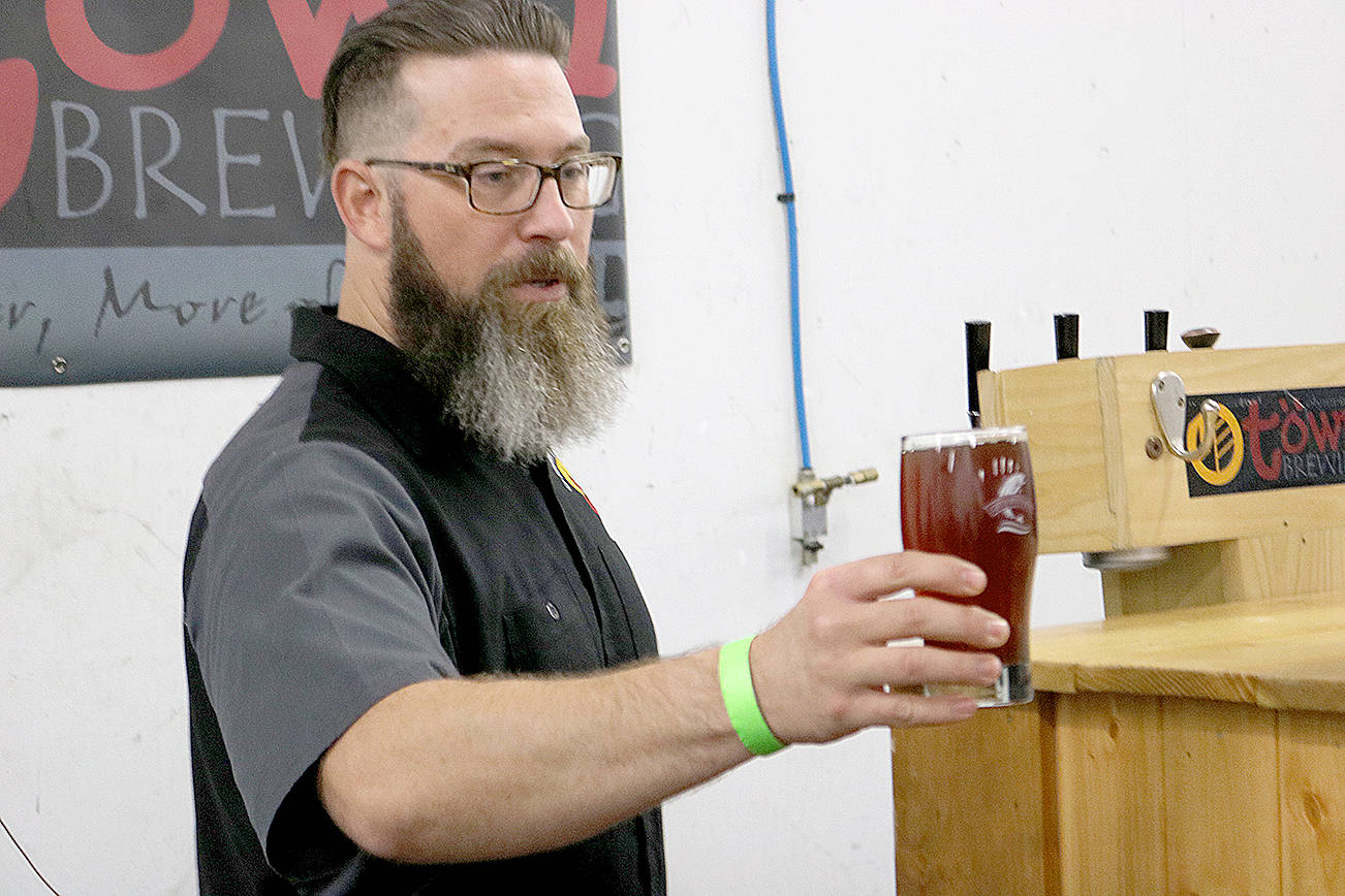 (Travis Rains | The Vidette) O-Town Brewing of Olympia was on-hand Saturday at Catch Montesano. Brewer Jason Stenzel is pictured here offering a freshly-poured beer to the large group of people congregated at Whitney’s detail shop.