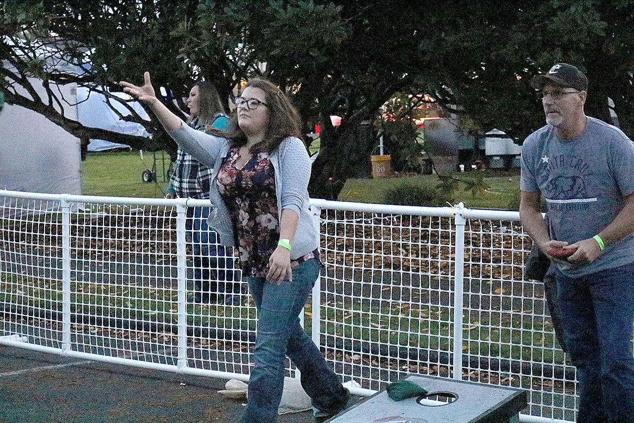 (Travis Rains | The Vidette) Ashley Belgin (left) competes against fellow Elma resident Dan Starks in the Catch Montesano Fish and Brew Fest cornhole tournament.