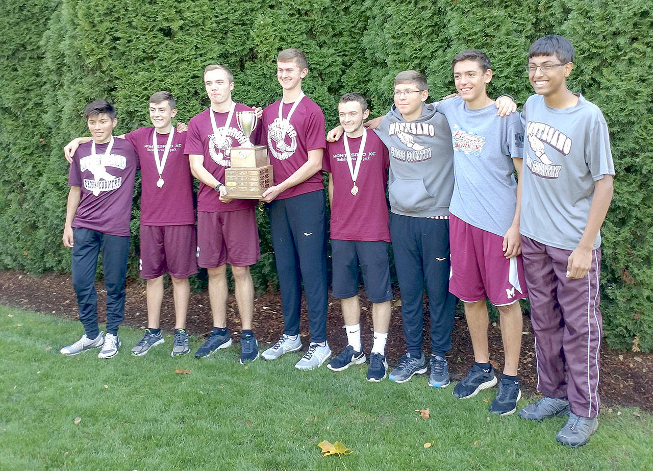 From left: Andy Fry,Martin Shuck, Connor Parkinson, Braden Stowers, Josef Aschenbrenner, Evan Ramstad, Tucker Stecher and Thomas Bergstrom stand with their medals and trophy after winning the district cross country championship on Saturday.