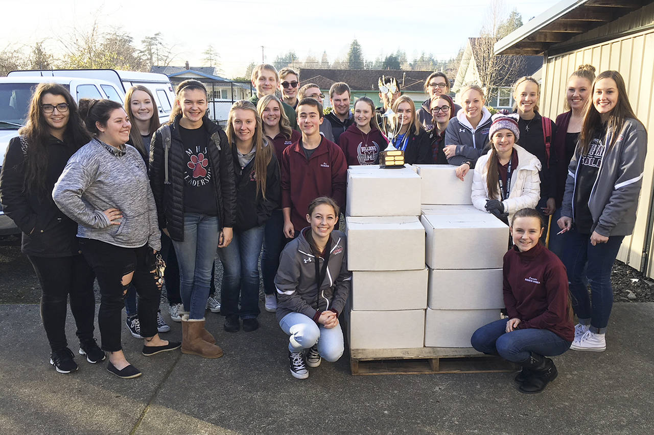 (Todd Bennington | The Vidette)                                Montesano students pose with a trophy earned during past Food Bowl competitions while waiting outside the Montesano Food Bank to help unload donations on the afternoon of Dec. 12.