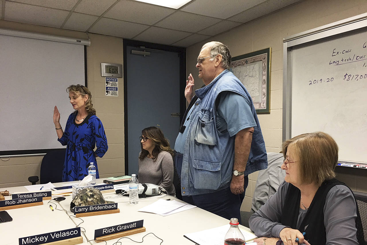 (Todd Bennington | The Vidette)                                Teresa Boling and Larry Bridenbaack are sworn in as Elma School District board members on Dec. 13. Also pictured are board member Bethany Whipple-Boling and district staff member Jenny House.