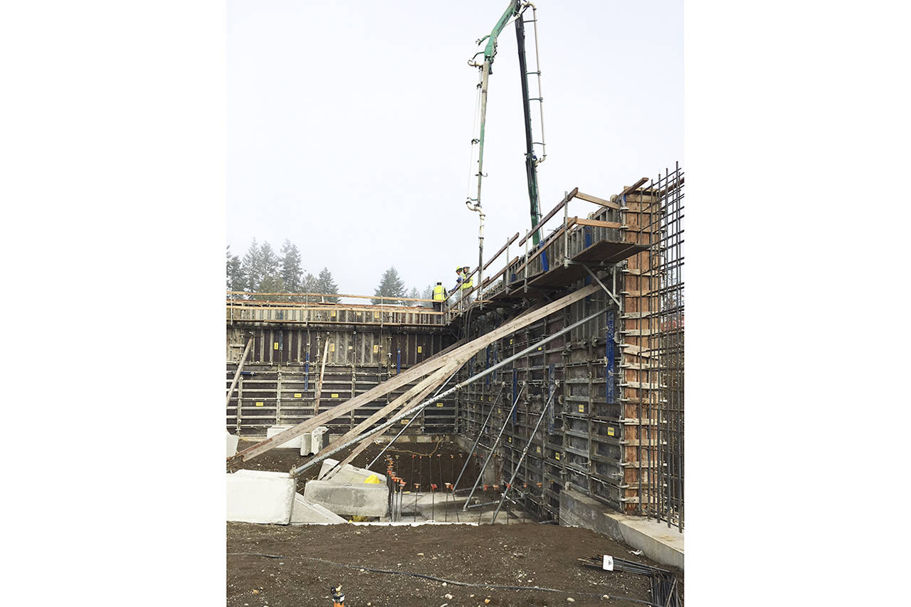 (Todd Bennington | The Vidette) A concrete wall for Summit Pacific Medical Centers new wellness center in Elma is poured by a crew on Dec. 21. Visible in the bottom center portion of the photo is what will eventually be the base of the facilitys elevator shaft.