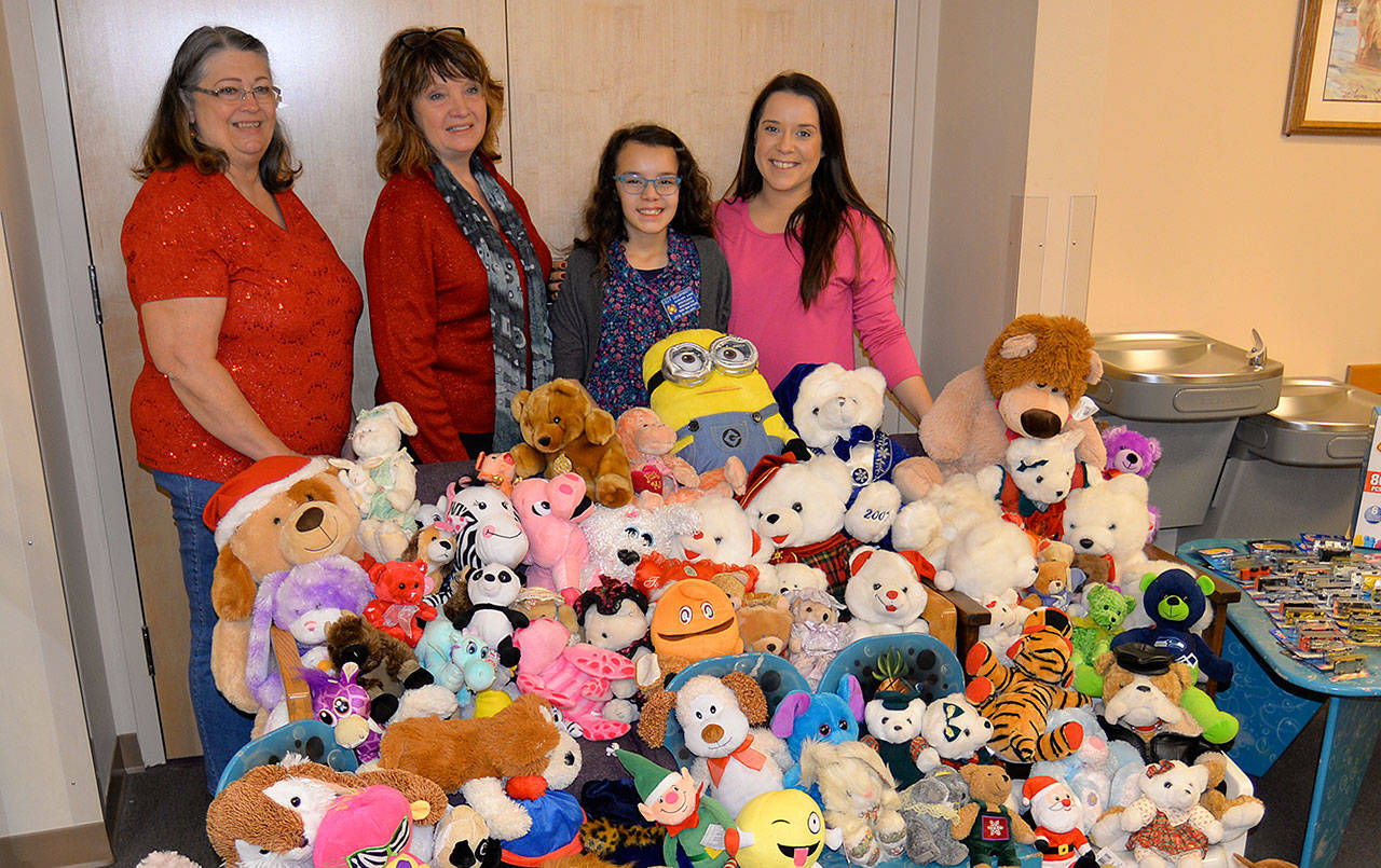 DAN HAMMOCK | THE DAILY WORLD                                Lilly Delahanty, the official Teddy Bear Officer for the Montesano VFW Auxiliary, shows off the stuffed toys she collected all year before donating them to the Children’s Administration Office in Aberdeen Friday. Pictured from left are VFW Auxiliary President T.J. Glick, Auxiliary Secretary Diane Nillson, Lilly and her mom, Ciara Brough.