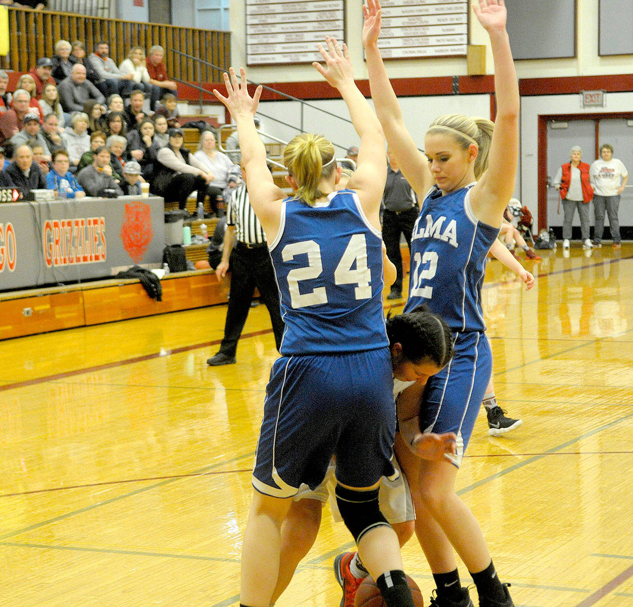 Elma’s Molly Johnston, left, and Brooke Sutherby clamp down on defense against a Hoquiam ball handler on Saturday night at Hoquiam Square Garden.