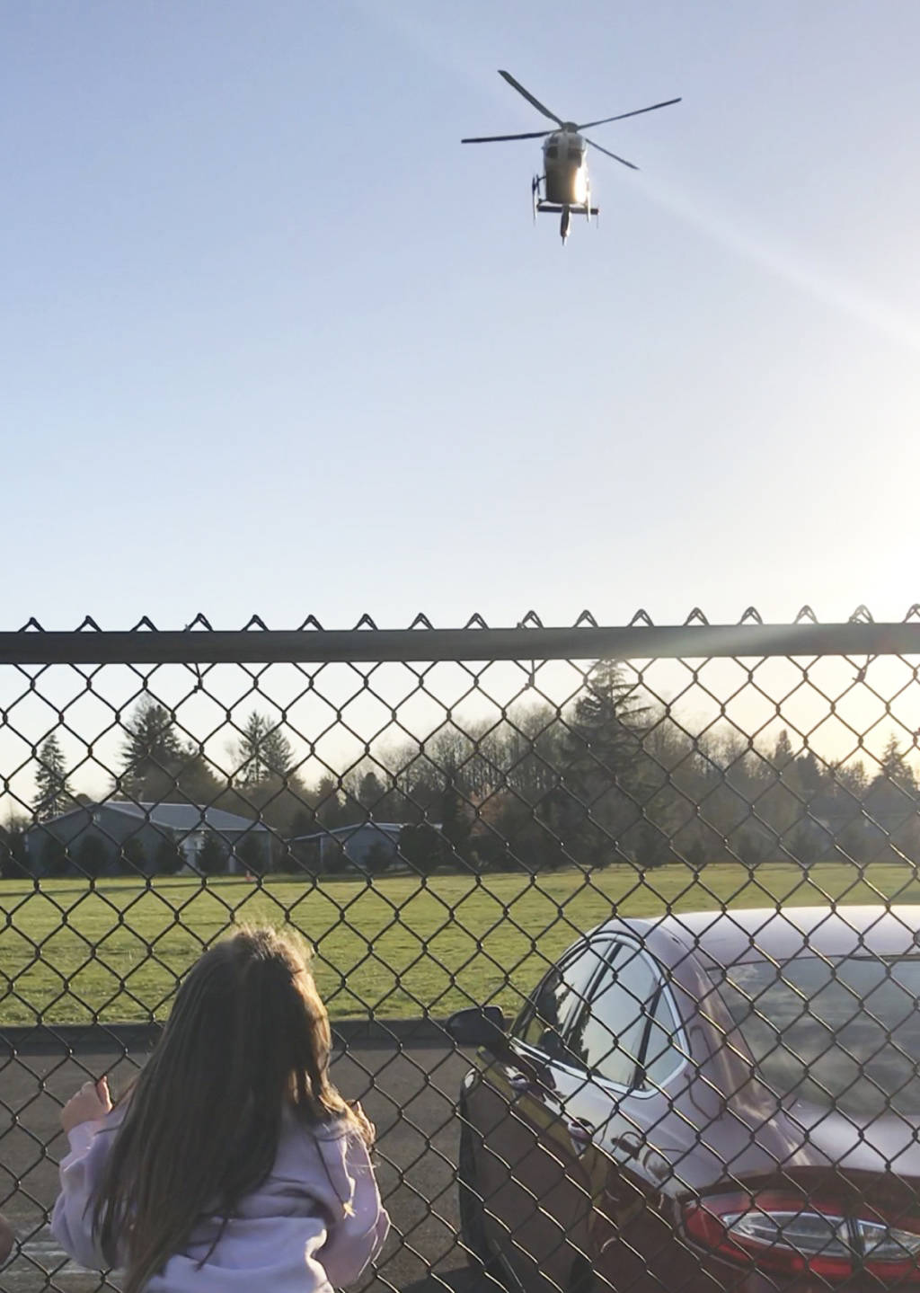 (Photo by Savannah Moorcroft) Paisley Moorcroft climbs a fence as an Airlift Northwest helicopter lifts off shortly before her Montesano Little League practice.