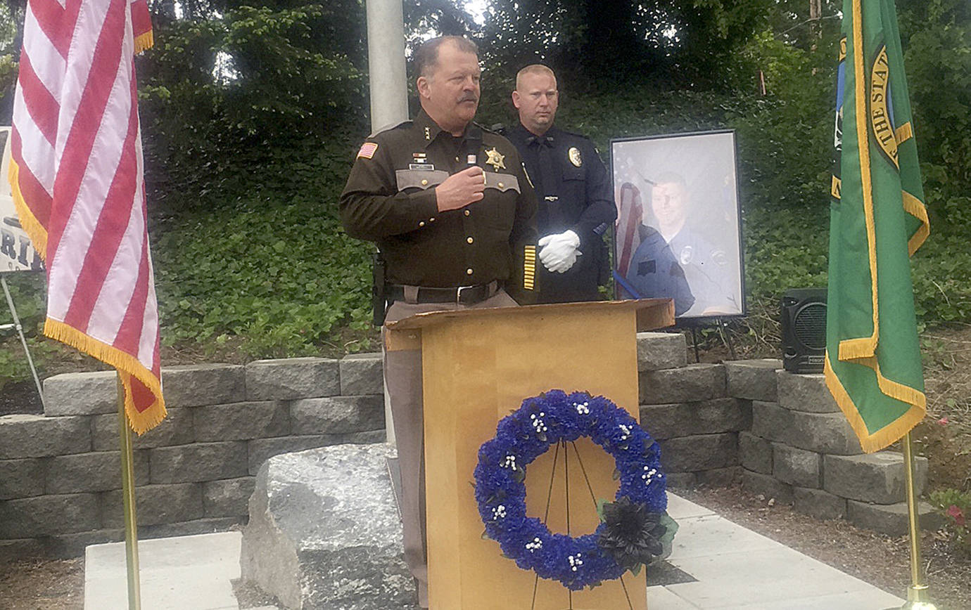 JEFF MYERS | HOQUIAM POLICE DEPARTMENT                                Grays Harbor County Sheriff Rick Scott spoke at the dedication of a first responder memorial in Elma Wednesday afternoon. Hoquiam Police Chief Jeff Myers also spoke about Daniel McCartney, the former Hoquiam Police officer who died in the line of duty this past January while a deputy with the Pierce County Sheriffs Office. In the background next to the photo of McCartney is Elma Police officer Josh Wheeler.
