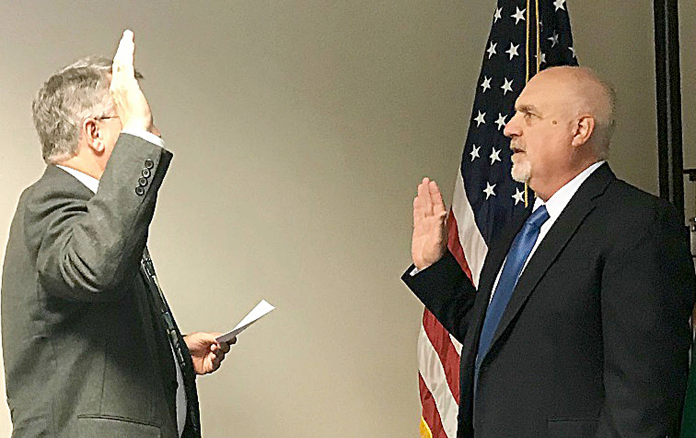 PHOTO COURTESY PORT OF GRAYS HARBOR                                Phil Papac of Montesano, right, is sworn in as Port of Grays Harbor District 1 commissioner Tuesday at the Satsop Business Park.