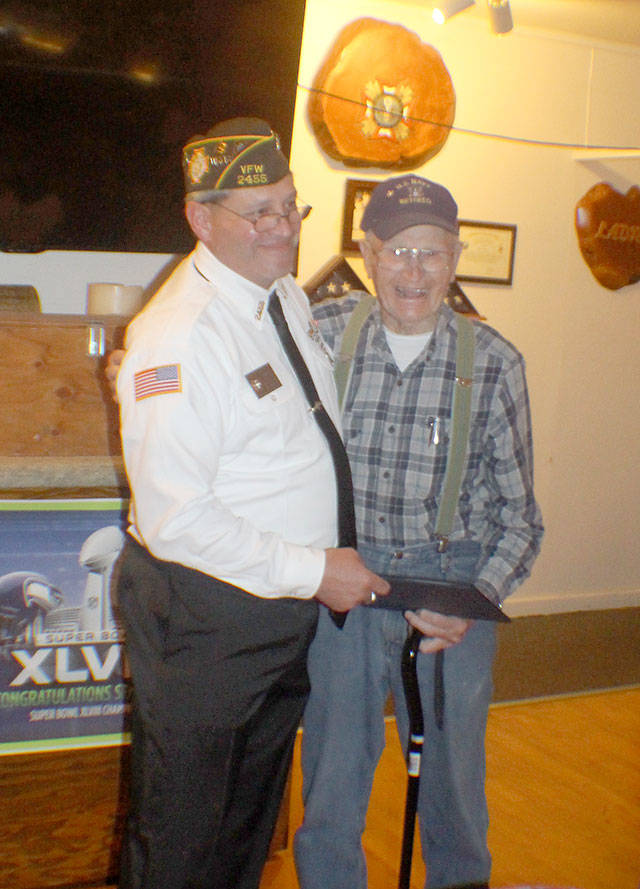 Michael Lang | The Vidette                                Commander Kyle Winkle, from left, of the Veterans of Foreign Wars Post 2455 in Montesano, presents a letter from VFW Commander-in-Chief Vincent “B.J.” Lawrence to Grant Edwards, right, during a ceremony Monday, Aug. 21, 2018, at the VFW hallin Montesano. The letter acknowledges Edwards’ 60 years of membership with the Montesano post. At 99 years old, he is believed to be the oldest veteran in Grays Harbor County. As a Marine, he was a hospital corpsman during World War II and the Korean War.