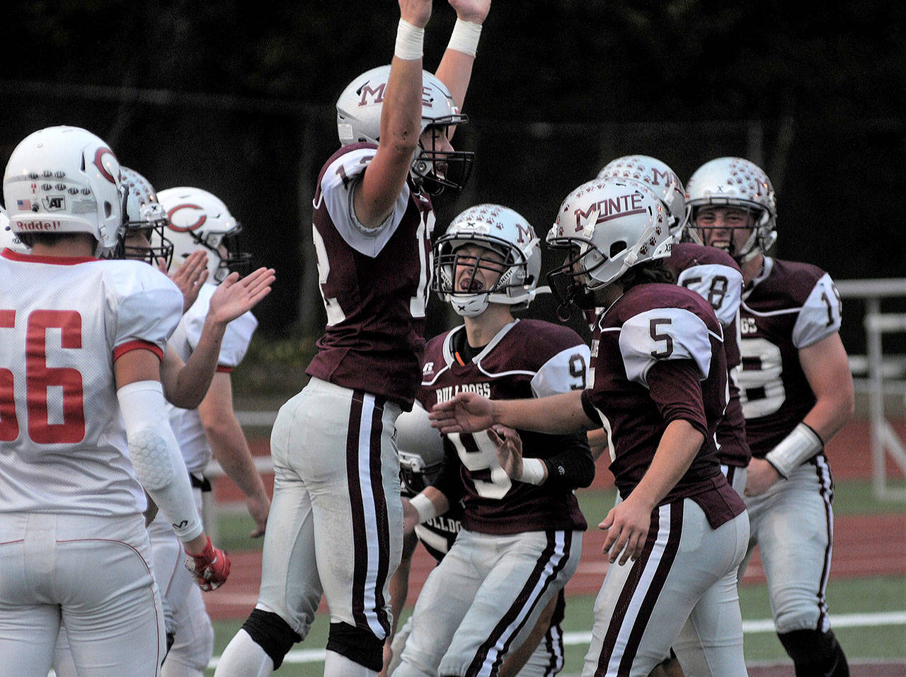 Montesano’s Sam Winter leaps for joy and celebrates with his teammates after scoring a touchdown against Columbia-White Salmon on Friday. (Hasani Grayson | The Daily World)