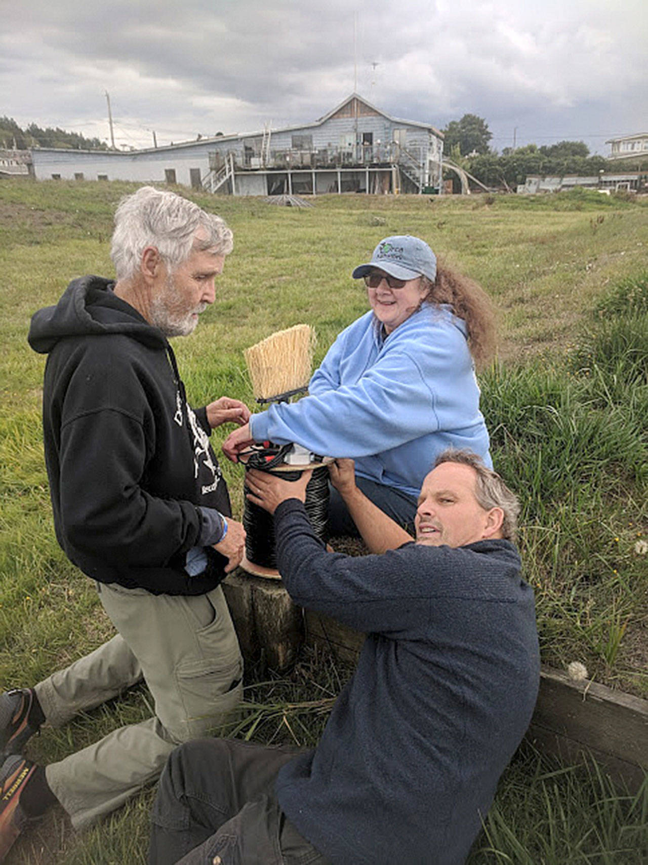 Courtesy photo                                Howard Garrett, left, Susan Berta and Florian Graner roll out the long cable needed to install a hydrophone to listen to marine life. The research sound equipment is located at Bush Point in the sound path of killer whales and other marine mammals. (Photo provided)