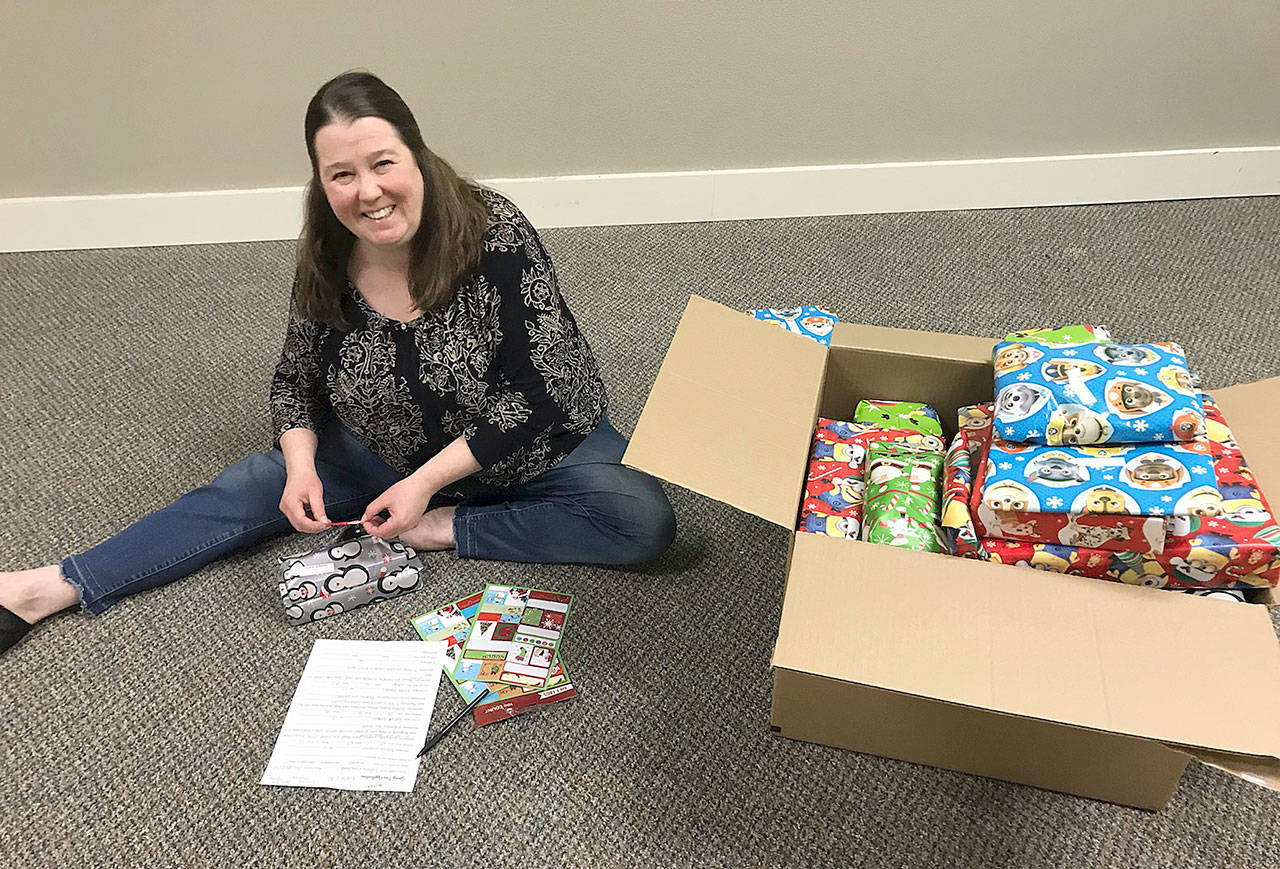 (Courtesy Kyna Wilson) Dawn Toney, a licensed mental health counselor at Olympia Therapy, prepares gifts for an effort led by Hands-On-Health Chiropractic to give Christmas presents to about 30 families in Grays Harbor County.