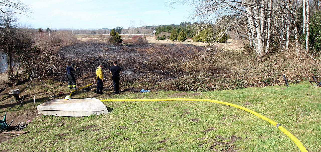 Firefighters from Montesano Fire Department and Grays Harbor Fire District 2 survey the scene Tuesday, March 19, while fighting a burn at 74 Devonshire Road west of Montesano. (Michael Lang | Grays Harbor News Group)