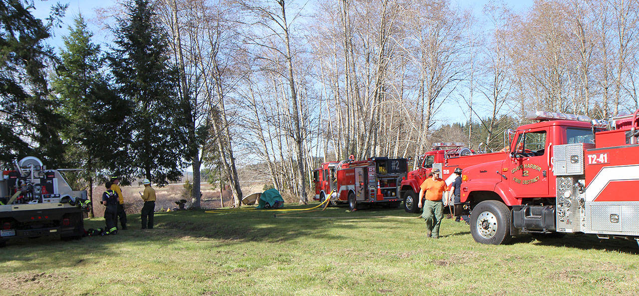 Firefighters from Montesano Fire Department and Grays Harbor Fire District 2 work the scene Tuesday, March 19, of a brush fire at 74 Devonshire Road west of Montesano. (Michael Lang | Grays Harbor News Group)