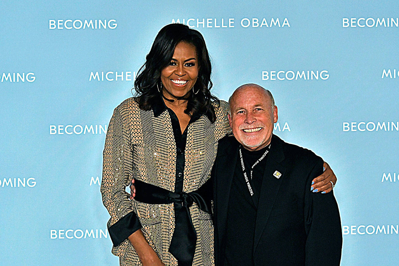 Lifelong Harborite and professional photographer Darrell Westmoreland poses with Michelle Obama. Westmoreland was an official photographer for the former first lady’s book tour event at the Tacoma Dome on Sunday.