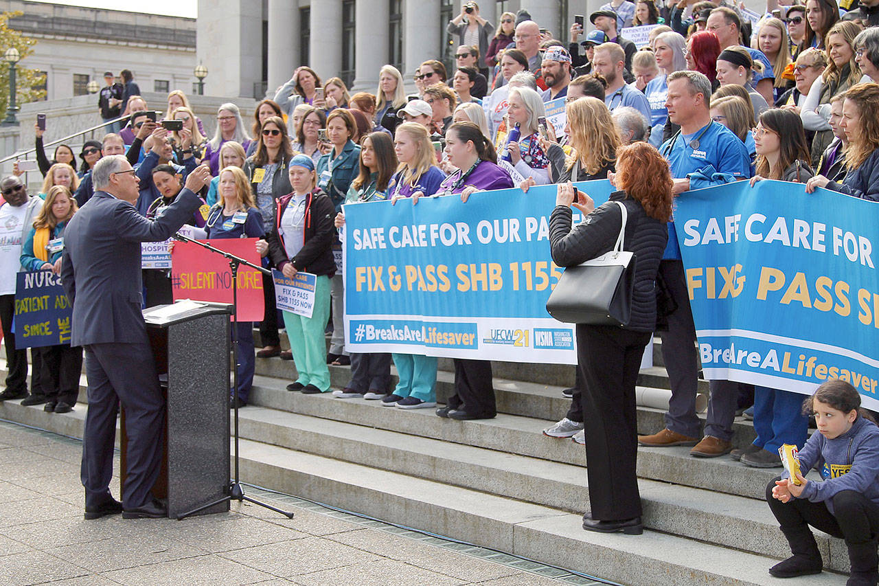 Gov. Jay Inslee (at podium) speaks Wednesday, April 24, on the Capitol steps in Olympia to protesting nurses. Inslee spoke on how important these breaks are for both workers and patient care. Inslee indicated he would sign it into law if it passes both chambers. – (Emma Epperly | Washington Newspaper Publishers Association)