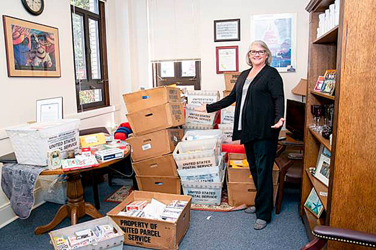 Sen. Maureen Walsh (R-College Place) poses Wednesday, April 24, in her office in Olympia with mail bins full of playing cards sent to her by people upset with her remarks critical of nurses made last week on the floor of the state Senate. Staff estimates they have received over 1,700 decks of cards. Walsh has since apologized for her comments. (Photo courtesy of the Washington State Legislature)