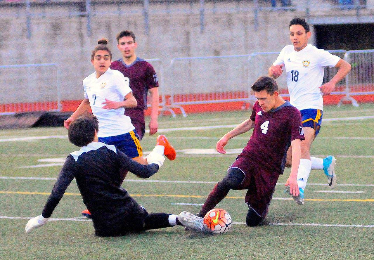Montesano’s Veli Ambrocio (4) is met by Forks keeper Gabriel Terrones in the box on a one-on-one opportunity in the second half on Wednesday. (Hasani Grayson | Grays Harbor News Group)
