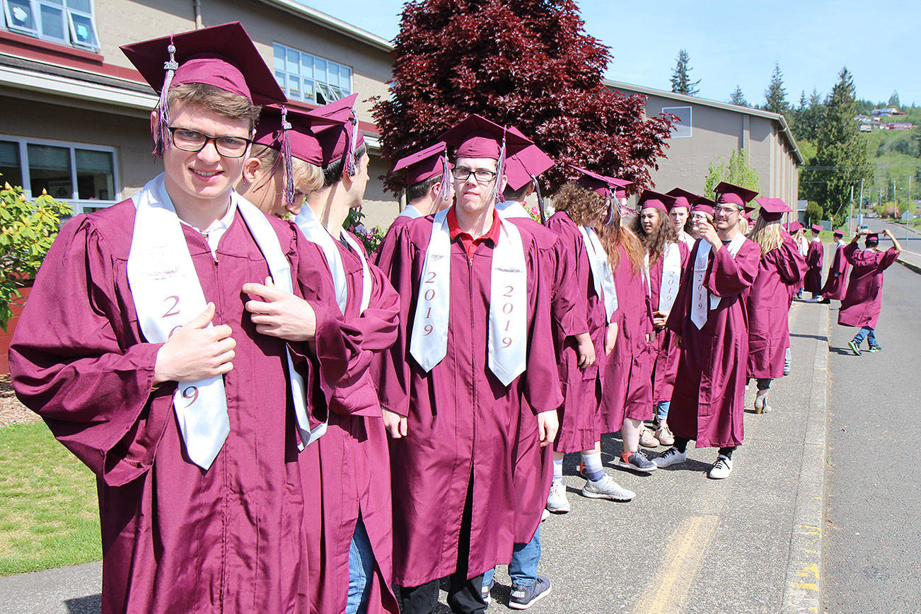 Max Urbanski (left) adjusts his outfit while waiting with other members of the Montesano Class of 2019 on Tuesday, May 7, to take the class picture in front of the Montesano school. (Michael Lang | Grays Harbor News Group)