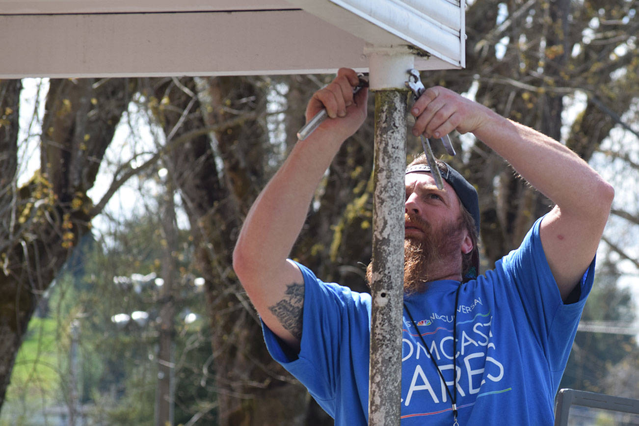 Volunteer AJ Andrade helps repair a post May 4 at the McCleary VFW post as part of Comcast Corp.’s Comcast Cares Day. A post leader said about 200 people showed up to do work around the building. (Photo courtesy Comcast Corp.)