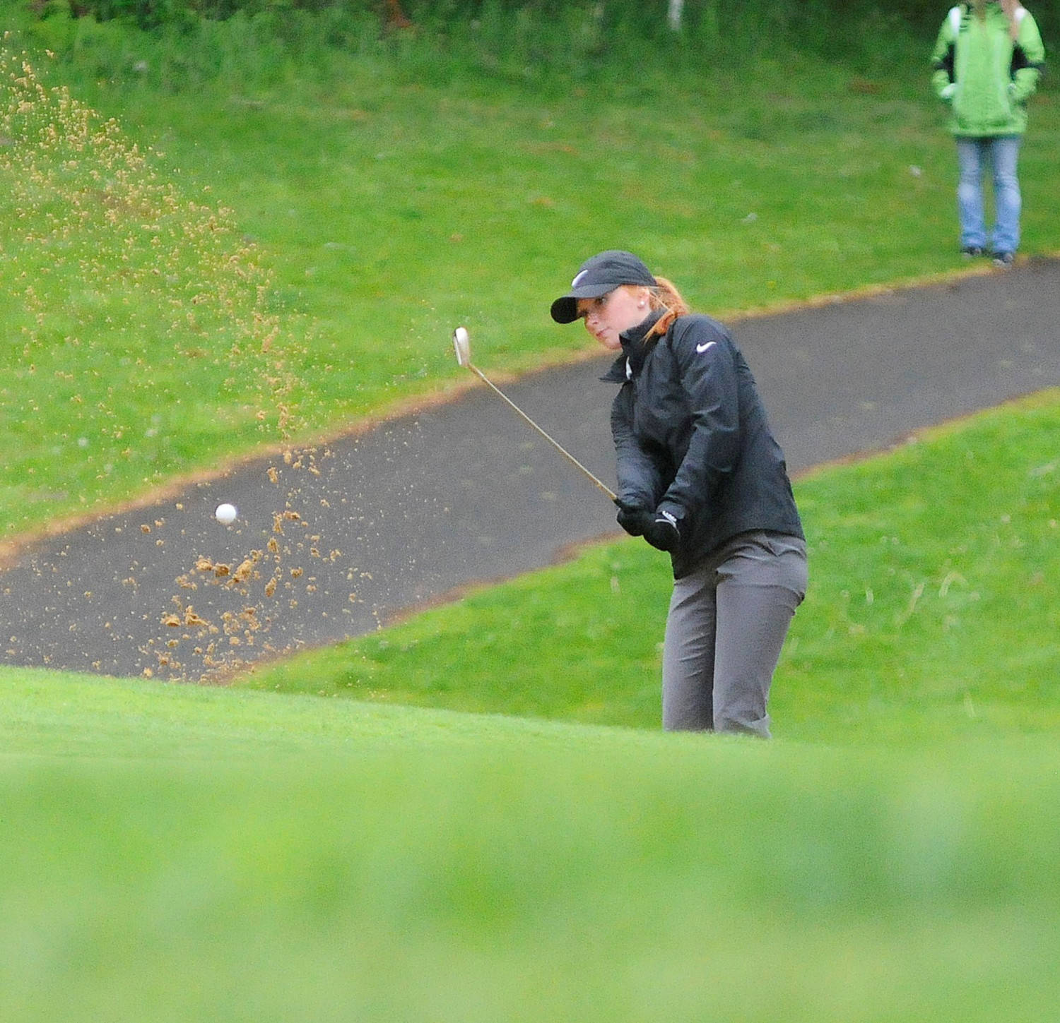 Montesano’s Glory Grubb chips out of a bunker on the fourth hole of the SWW1A District Golf Tournament on Tuesday in Tumwater. Grubb finished third overall. (Hasani Grayson |Grays Harbor News Group)