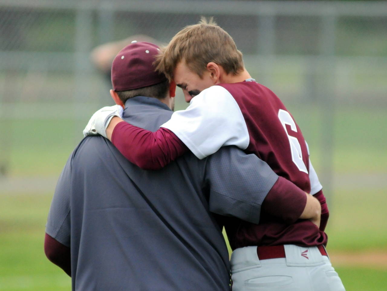 Montesano’s Cole Daniels is consoled after the final out of the Bulldogs’ 4-3 loss to Seattle Christian in a 1A regional final at Castle Rock High School. (Ryan Sparks | Grays Harbor News Group)