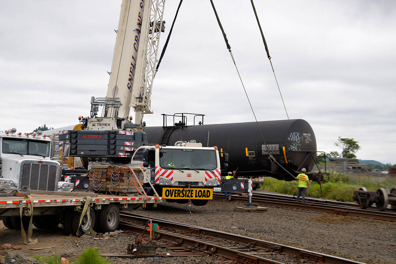 (Louis Krauss | Grays Harbor News Group) A crane prepares to place one of the train cars that derailed Saturday in Aberdeen back onto the tracks.