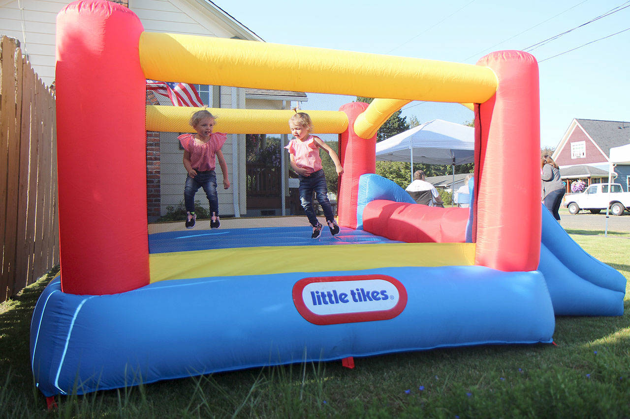 Eastyn (left) and Emersyn Frafjord, both 2, of Montesano enjoy a bounce house Tuesday during a National Night Out event in Montesano (Michael Lang | Grays Harbor News Group)