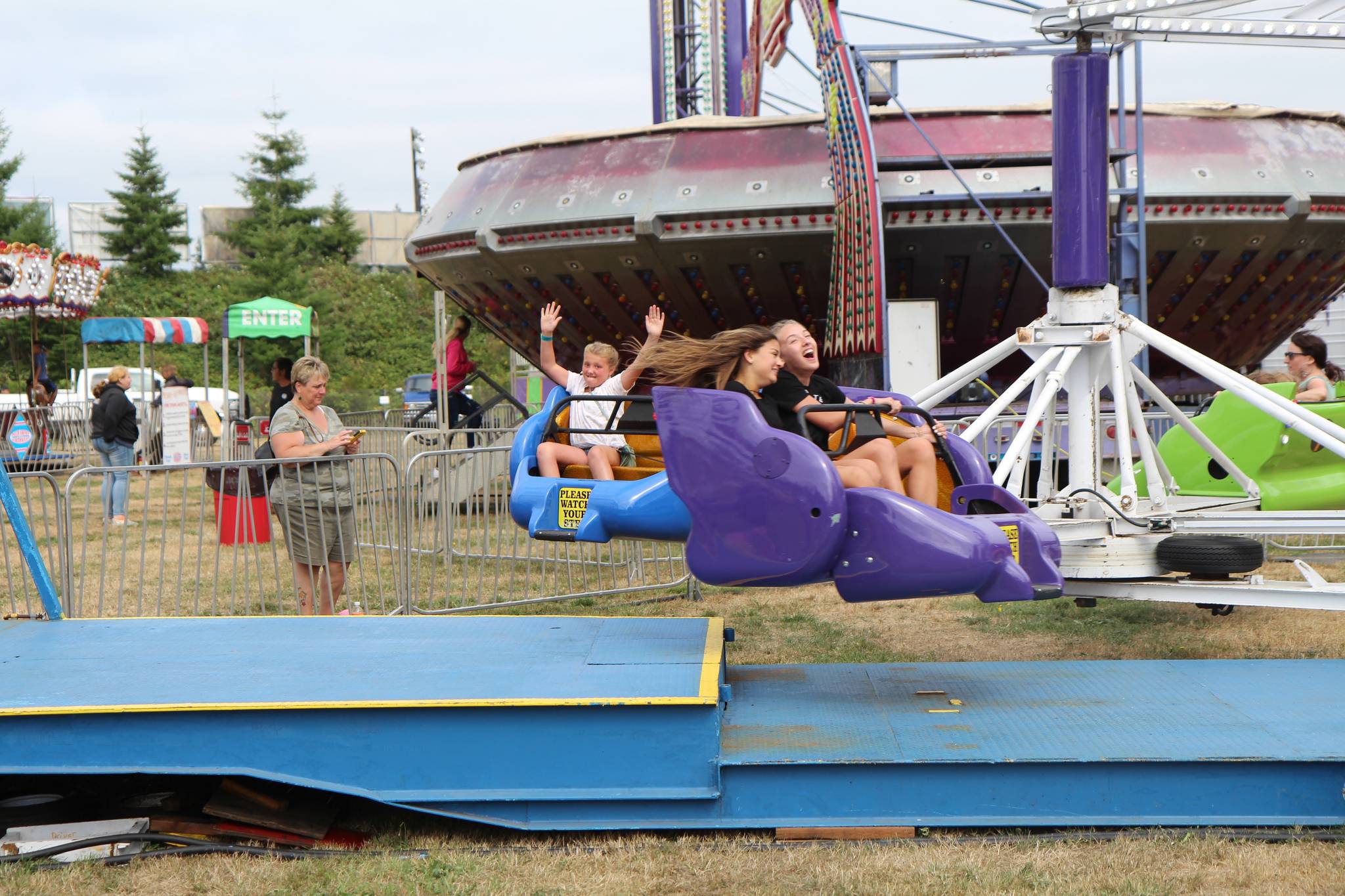Riders go for a spin at the Fair.                                Riders go for a spin at the Fair.