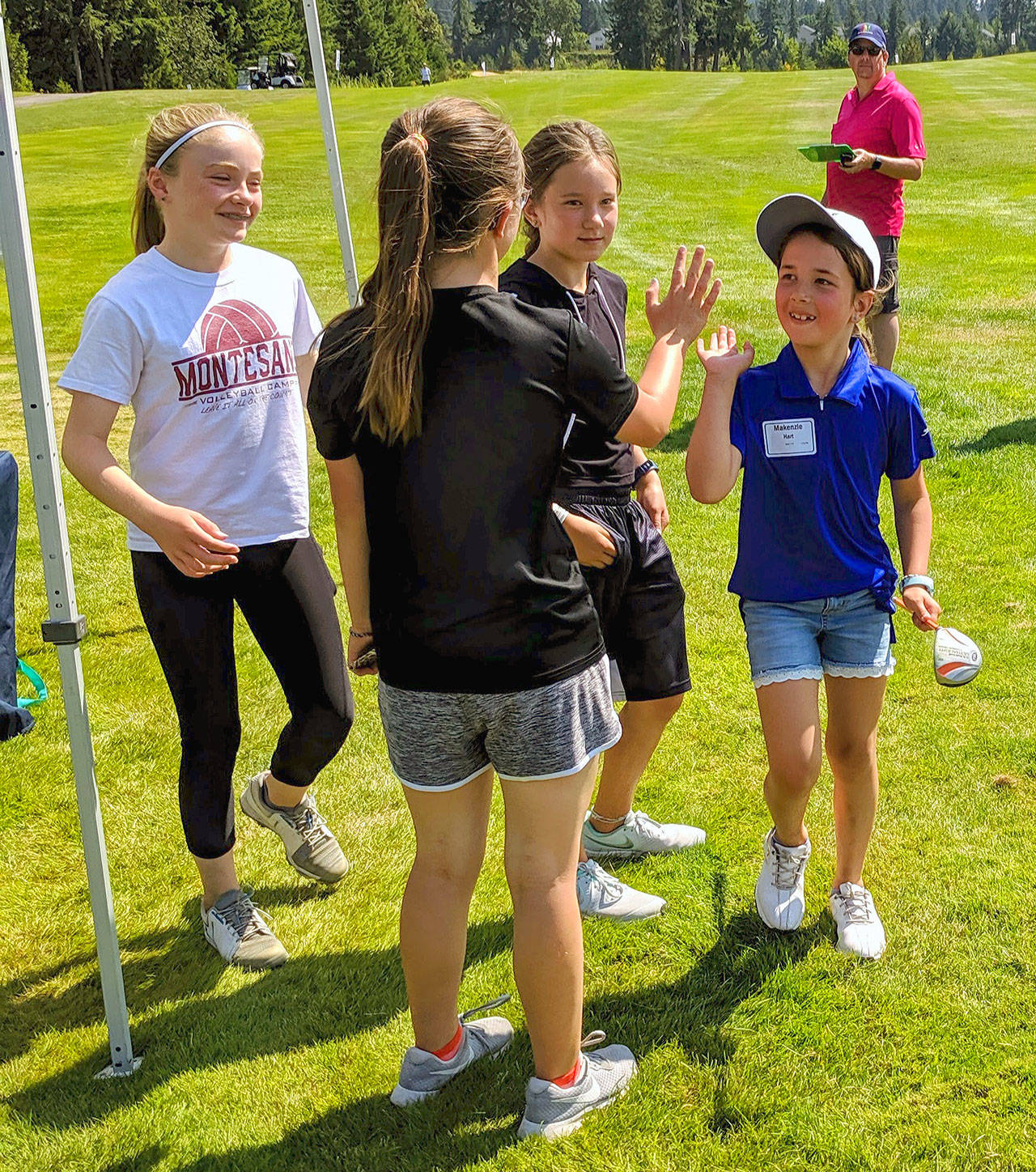 Makenzie Hart, right, gives a high five to a fellow golfer after competing in the drive portion of the Drive, Chip & Putt competition on Aug. 5. Hart took third in the putt portion of the contest. (Submitted Photo)