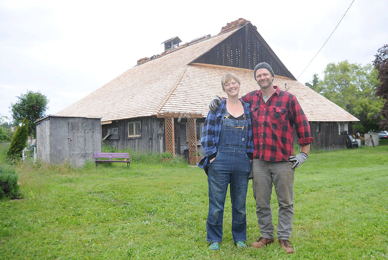 Rebecca Olson and Doug Mazzeo stand near the historic barn at Lavender Connection. The farm, owned by Richard and Susan Olson, received a state matching-funds grant to restore the barn once owned by the Lotzgesell family in the 1910s. (Michael Dashiell/Olympic Peninsula News Group)