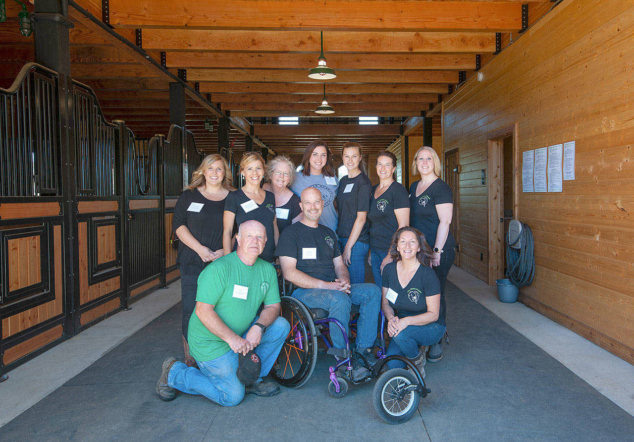 Event organizers pose for a photo Monday, Aug. 26, 2019 in stables on a farm north of Hoquiam. From left are (front row) Dave Miller, board president Jeff Miller and Wanda Wall. In the back row are (from left) Jenny LaDue, Georgia Bravos, Cathy Finney, Summit Pacific registered nurse Kim Iverson, Hailey Jones, Trisha Jones and Shelley Robinette. (Photo courtesy Kristi Norberg)