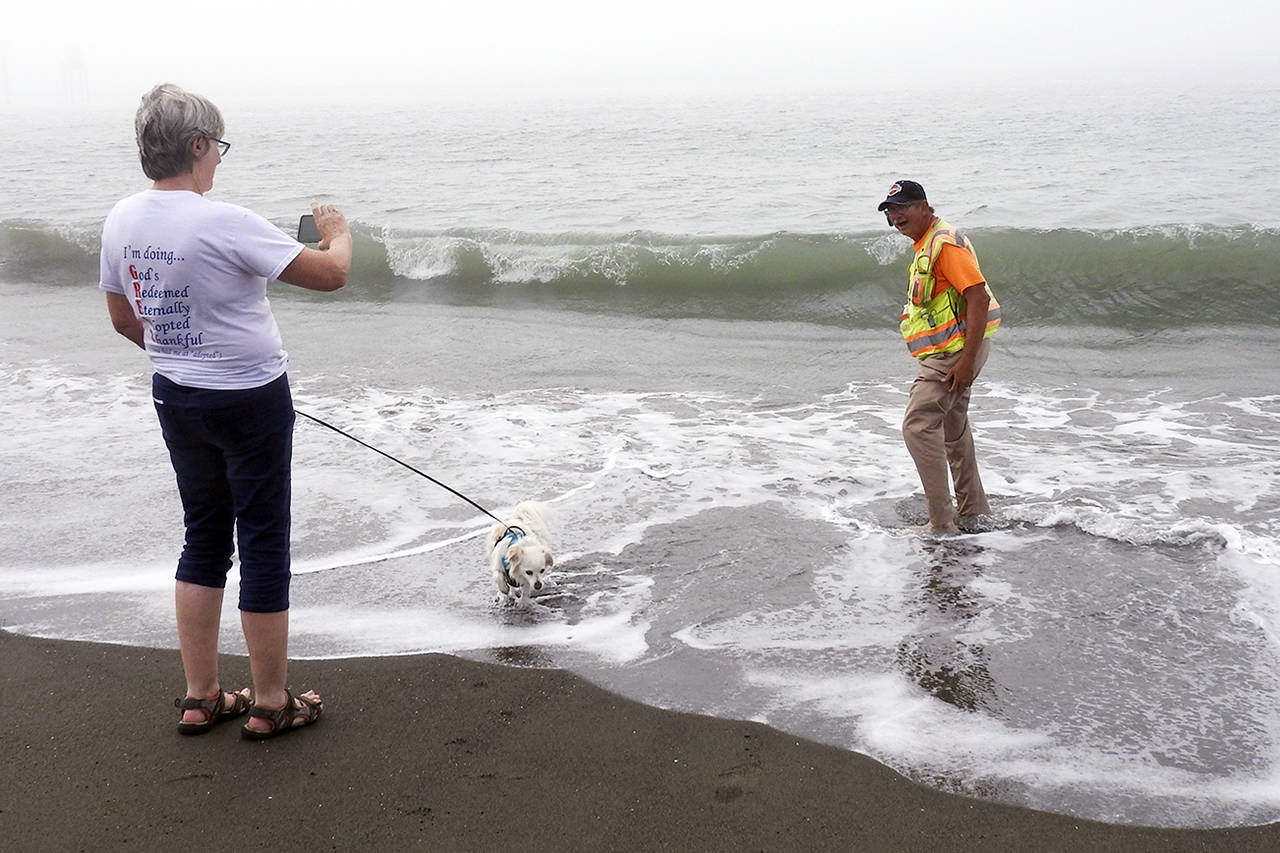 Kat Bryant | Grays Harbor News Group                                Glenn Koster finishes his coast-to-coast walk at 4:10 p.m. Wednesday at Half Moon Bay in Westport, accompanied by his wife, Charlcie, and their dog, Walker.
