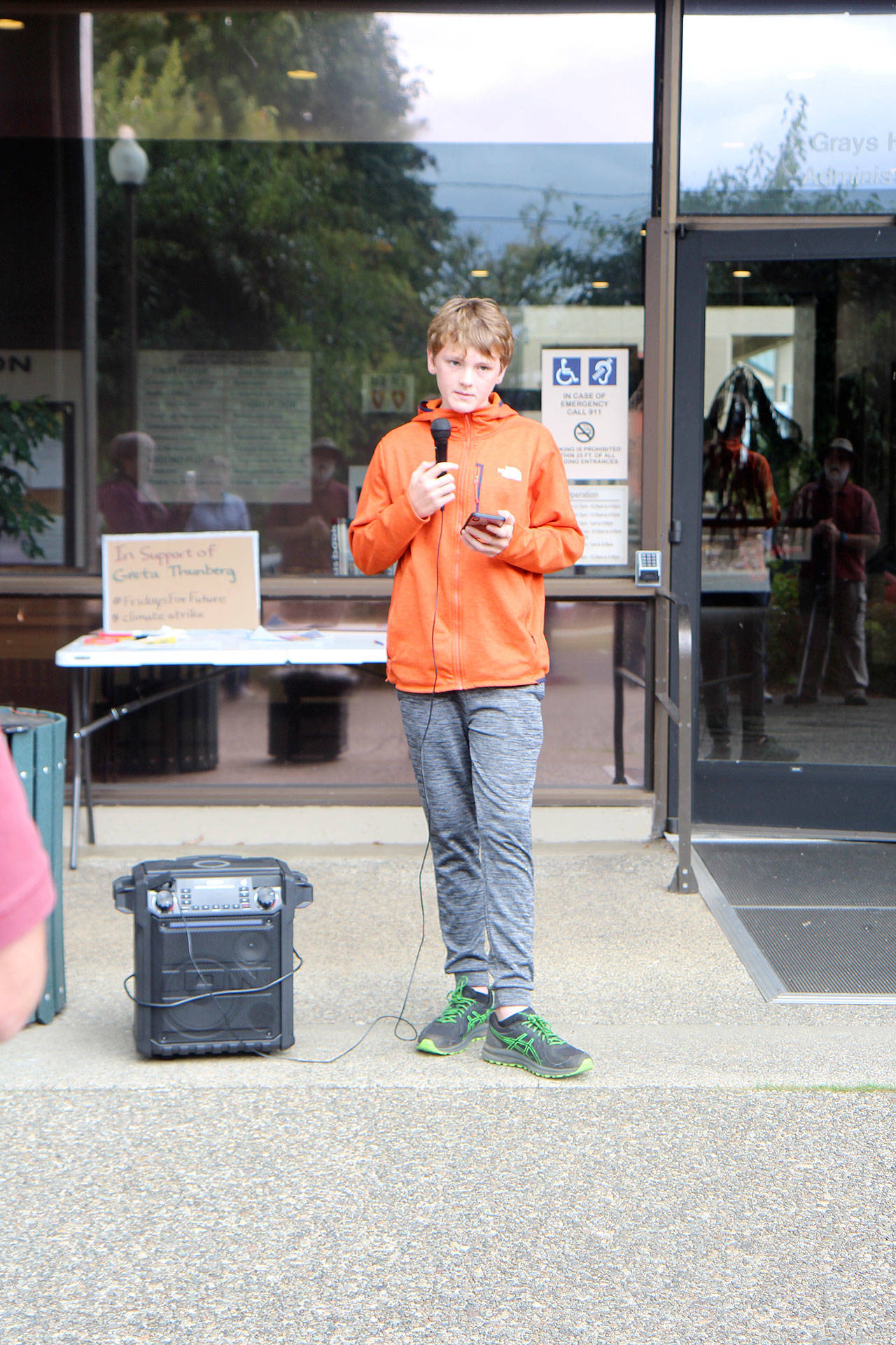 Michael Lang | Grays Harbor News Group                                Aberdeen freshman Will Boling reads a statement to the crowd Friday, Sept. 20, in front of the county administration building in Montesano as part of a global climate strike.