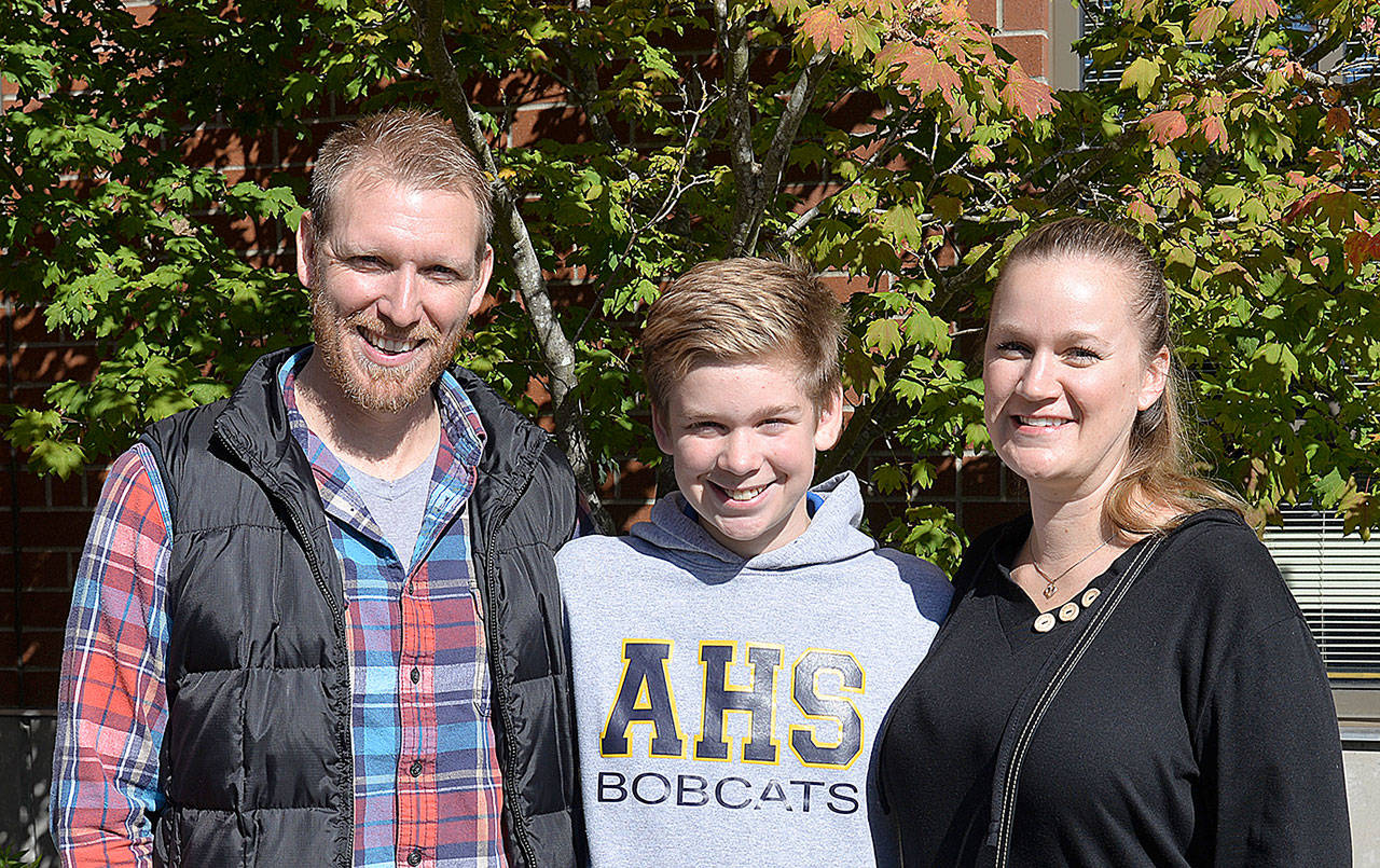 DAN HAMMOCK | GRAYS HARBOR NEWS GROUP                                Aberdeen Police Officer Loren Neil, left, with his son Aiden and wife, Jodi, outside Aberdeen High School. The father-son team produced a video featuring the stories of 11 local drug addicts in hopes of providing another prevention tool for viewers in the region.