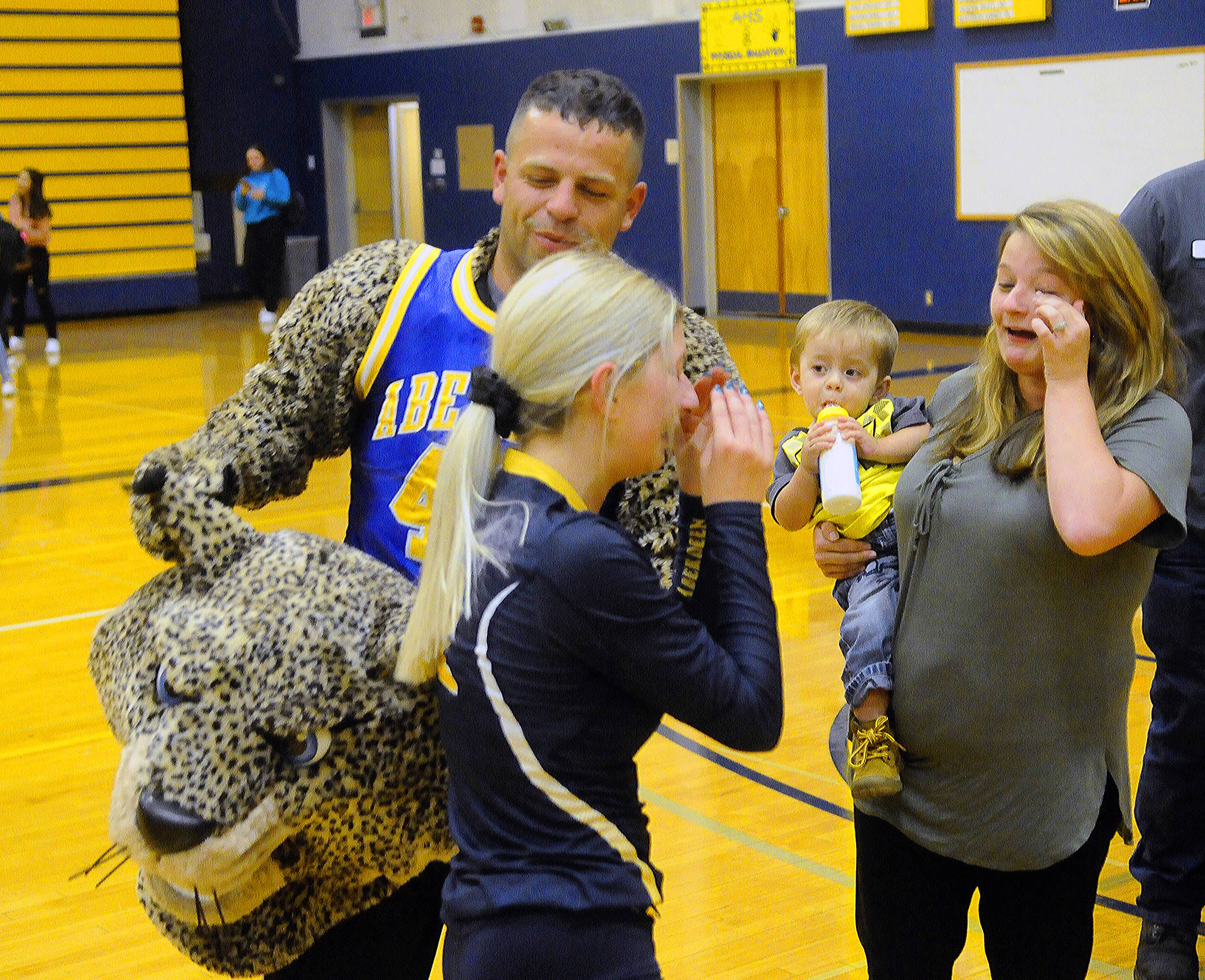 Aberdeen volleyball player Abby Baumgardner, left, and her sister Kayla Heden share tears after Army Sgt. Bradley Heden surprised Baumgardner by revealing himself before a match on Oct. 9.