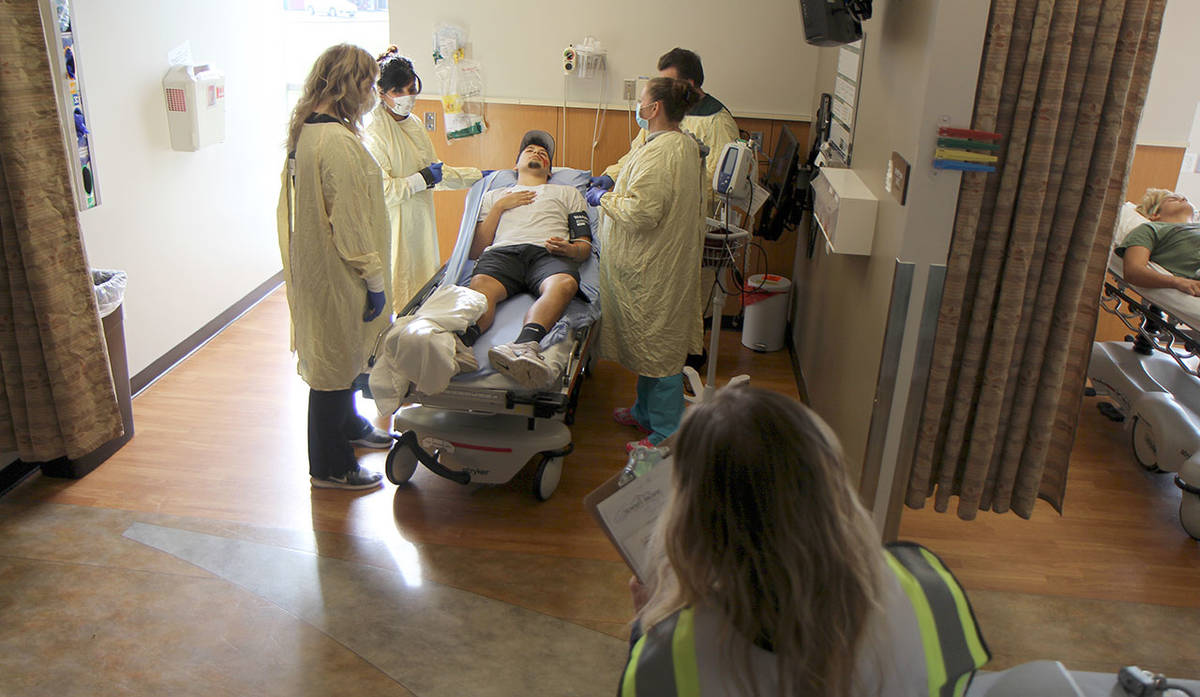 A doctor, two nurses and an emergency room technician evaluate “patient” Jesus Torres (on bed) during an emergency preparedness drill Wednesday, Oct. 23, at Summit Pacific Medical Center in Elma. (Michael Lang | Grays Harbor News Group)
