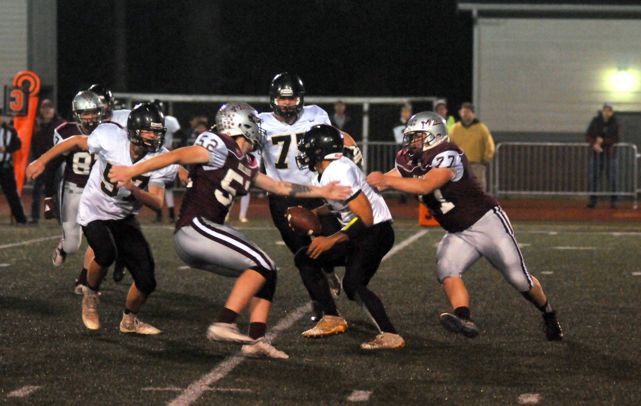 Montesano defensive lineman Kenny Koonrad, right, grabs hold of Meridian quarterback Cam Webster during Saturday’s state-playoff game at Jack Rottle Field. (Ryan Sparks | Grays Harbor News Group)